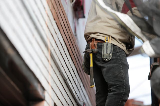 Person working outside with a hammer